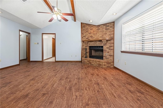 unfurnished living room with a textured ceiling, wood finished floors, ceiling fan, baseboards, and a fireplace