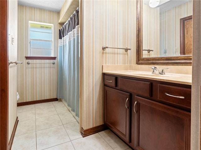 bathroom with wallpapered walls, baseboards, vanity, toilet, and tile patterned floors