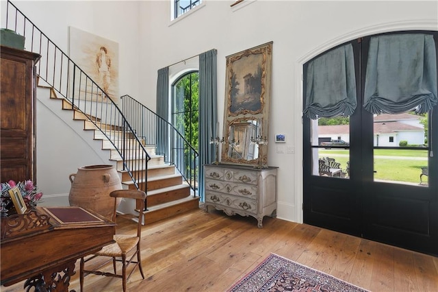 181 Windermere Way, Madisonville, LA 70447 - foyer entrance with light wood-style flooring, stairs, baseboards, a high ceiling, and french doors