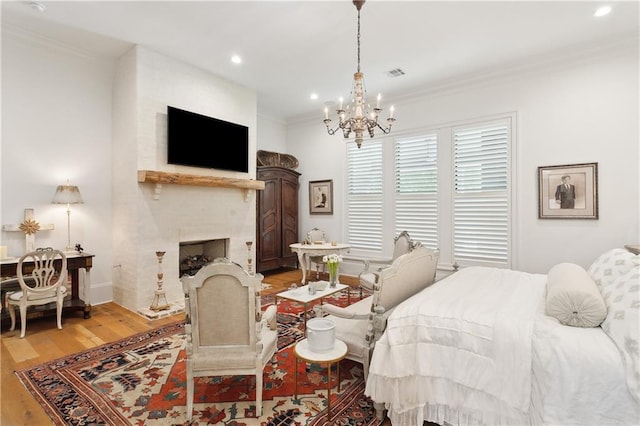 181 Windermere Way, Madisonville, LA 70447 - bedroom featuring light wood finished floors, a chandelier, crown molding, a fireplace, and recessed lighting
