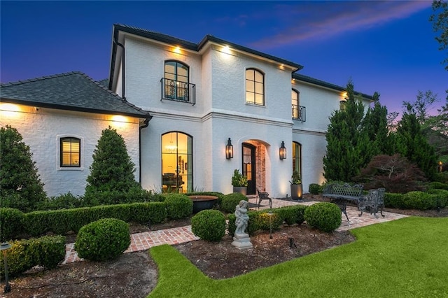 181 Windermere Way, Madisonville, LA 70447 - view of front facade featuring a lawn, a patio area, and a balcony