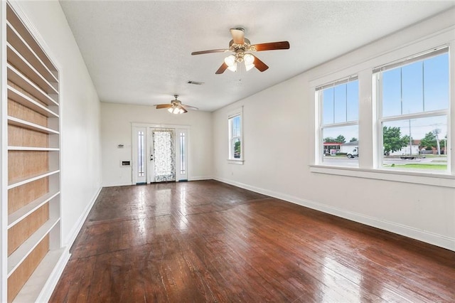 unfurnished room with hardwood / wood-style flooring, ceiling fan, baseboards, and a textured ceiling