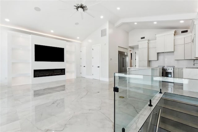 8116 Breakwater Dr, New Orleans, LA 70124 - living room with a glass covered fireplace, light marble finish flooring, high vaulted ceiling, recessed lighting, and baseboards
