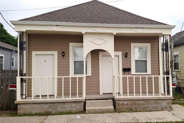 934 Brooklyn St, New Orleans, LA 70114 - shotgun-style home featuring roof with shingles and a porch