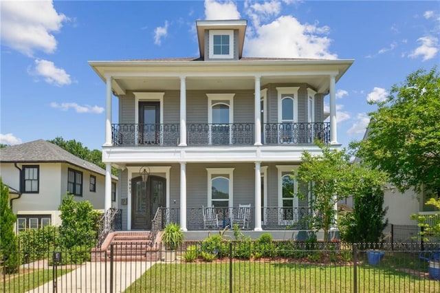 view of front of house with a porch, a balcony, and fence