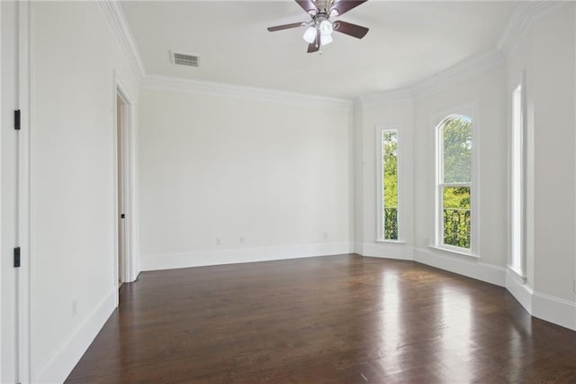 empty room with dark wood-type flooring, a ceiling fan, crown molding, and baseboards