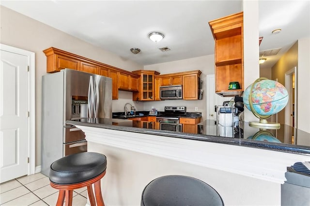 3945 Jean Lafitte Pkwy, Chalmette, LA 70043 - kitchen featuring stainless steel appliances, a sink, dark countertops, open shelves, and brown cabinets
