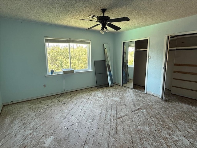 200 Macque St, Harahan, LA 70123 - unfurnished bedroom featuring multiple closets, a textured ceiling, wood finished floors, and a ceiling fan