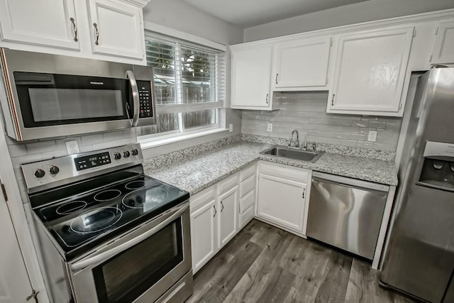 8209 Harris Ave, Harahan, LA 70123 - kitchen with appliances with stainless steel finishes, a sink, white cabinets, backsplash, and dark wood finished floors
