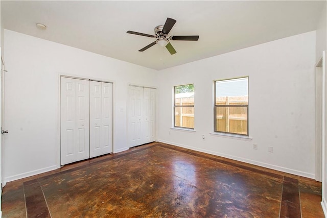 309 2nd Ave, Hammond, LA 70403 - unfurnished bedroom featuring two closets, concrete flooring, baseboards, and ceiling fan