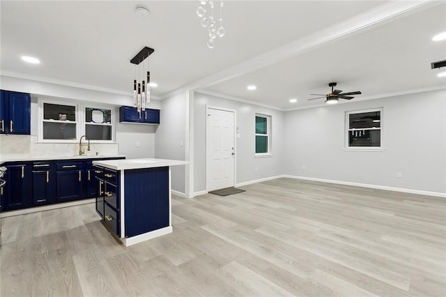 672 Wiegand Dr, Westwego, LA 70094 - kitchen featuring blue cabinets, a center island, recessed lighting, crown molding, and a sink