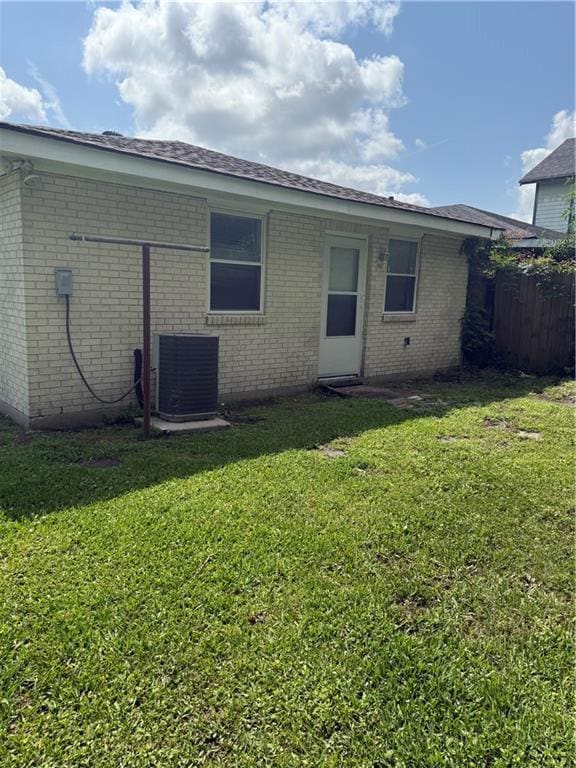 rear view of property with central AC unit and brick siding