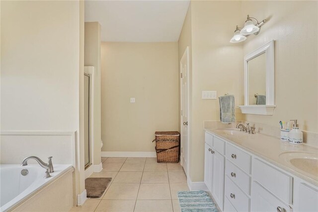119 Kasey St, Slidell, LA 70458 - full bathroom featuring tile patterned floors, double vanity, a bath, a stall shower, and baseboards