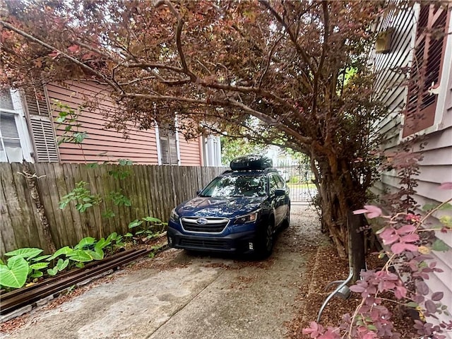 view of vehicle parking with fence
