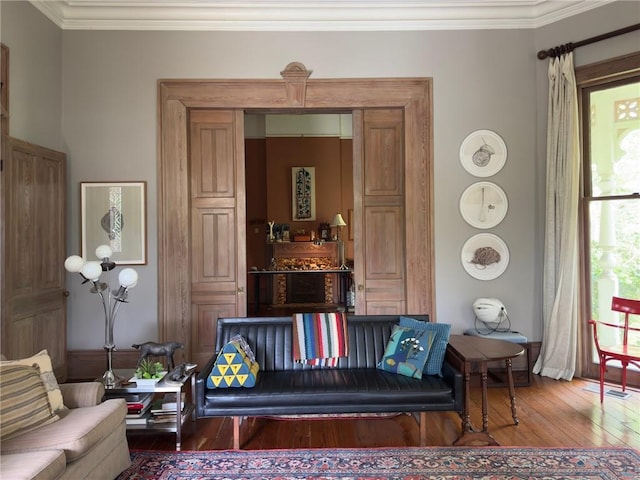 sitting room with hardwood / wood-style flooring and crown molding