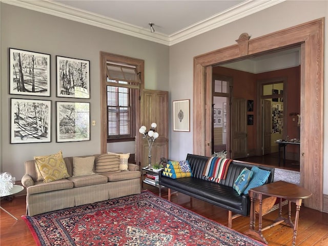 living area with wood finished floors and ornamental molding