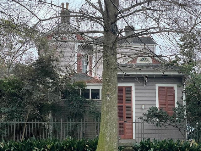rear view of property with fence and a chimney