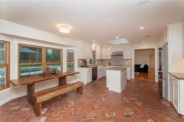 156 Oak Holw, Hammond, LA 70401 - kitchen with under cabinet range hood, brick flooring, tasteful backsplash, dishwasher, and a center island