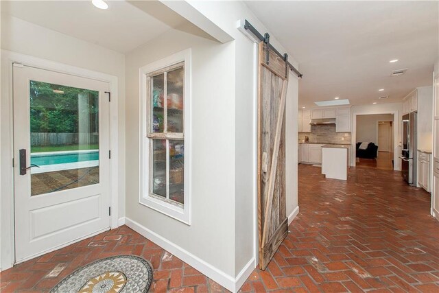 156 Oak Holw, Hammond, LA 70401 - corridor featuring brick floors, a barn door, baseboards, and recessed lighting