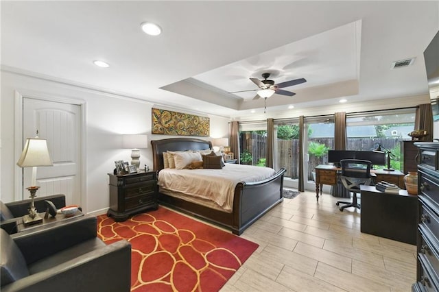 bedroom with a tray ceiling, ornamental molding, recessed lighting, a desk, and ceiling fan