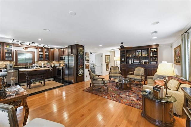 living room featuring light wood-style floors, ceiling fan, recessed lighting, and ornamental molding