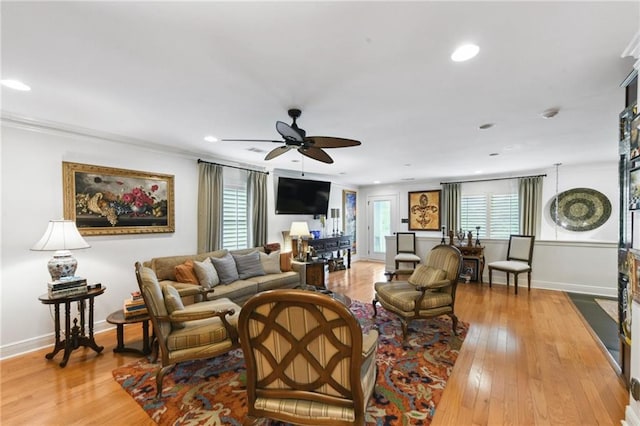 living area featuring light wood-style floors, a ceiling fan, baseboards, crown molding, and recessed lighting