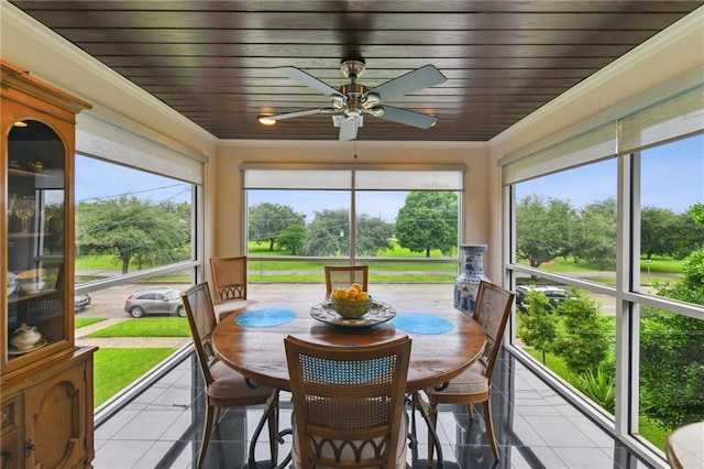 sunroom / solarium featuring tile patterned floors, ceiling fan, crown molding, and healthy amount of natural light