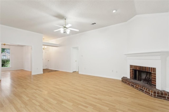 1155 Milan Dr, Mandeville, LA 70448 - unfurnished living room featuring ornamental molding, vaulted ceiling, a ceiling fan, light wood finished floors, and a fireplace