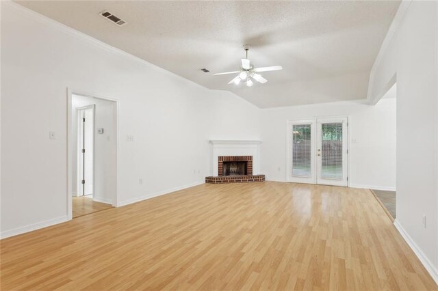 1155 Milan Dr, Mandeville, LA 70448 - unfurnished living room with ceiling fan, light wood-style floors, a brick fireplace, ornamental molding, and vaulted ceiling