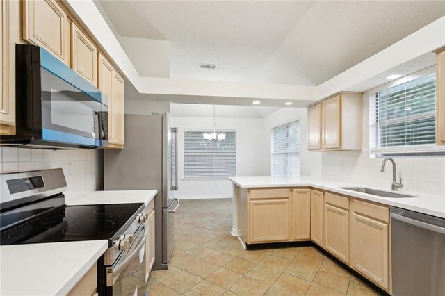 1155 Milan Dr, Mandeville, LA 70448 - kitchen featuring appliances with stainless steel finishes, light brown cabinets, a chandelier, a peninsula, and recessed lighting