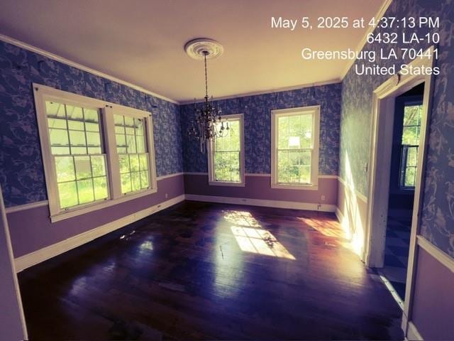 6396 10th Hwy, Greensburg, LA 70441 - unfurnished dining area featuring ornamental molding, wood finished floors, baseboards, wallpapered walls, and a chandelier