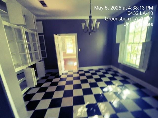 6396 10th Hwy, Greensburg, LA 70441 - unfurnished dining area with tile patterned floors, a chandelier, plenty of natural light, and baseboards