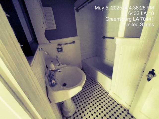 6396 10th Hwy, Greensburg, LA 70441 - bathroom featuring a sink, wainscoting, and a bath