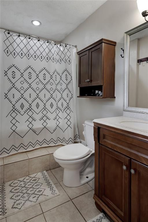 full bathroom featuring tile patterned floors, toilet, vanity, shower / tub combo with curtain, and recessed lighting
