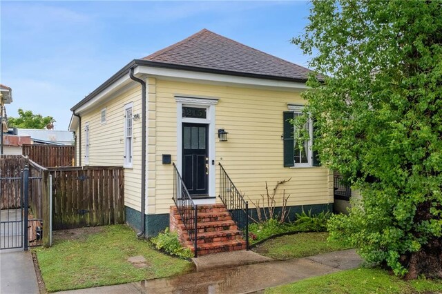 215 N Scott St, New Orleans, LA 70119 - view of front of home with fence, entry steps, and roof with shingles