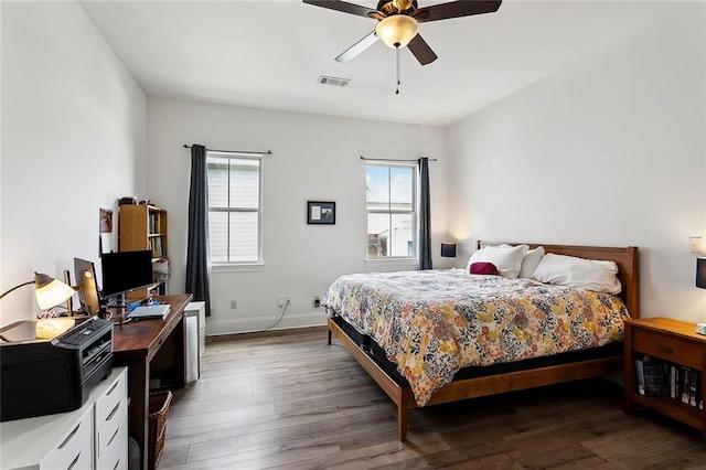 bedroom with wood finished floors, an office area, baseboards, and ceiling fan