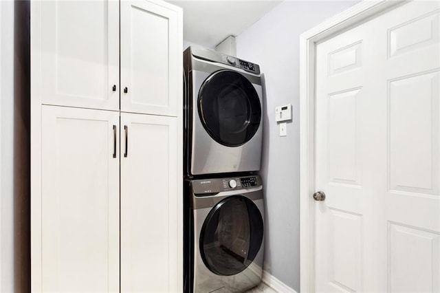 142 Lazy Creek Dr, Mandeville, LA 70471 - laundry area featuring stacked washing machine and dryer, cabinet space, and baseboards