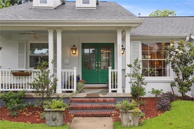 entrance to property featuring roof with shingles, ceiling fan, a porch, and french doors