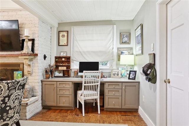 office space with light wood-style floors, ornamental molding, and a fireplace