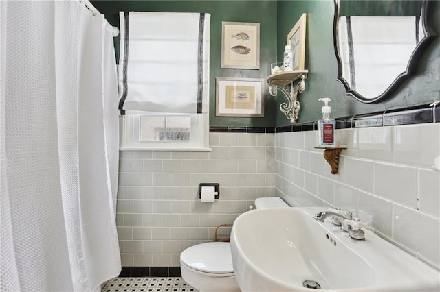 full bathroom with toilet, tile walls, a shower with shower curtain, and a sink