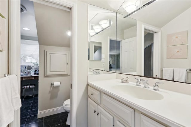 bathroom with toilet, vanity, and tile patterned floors