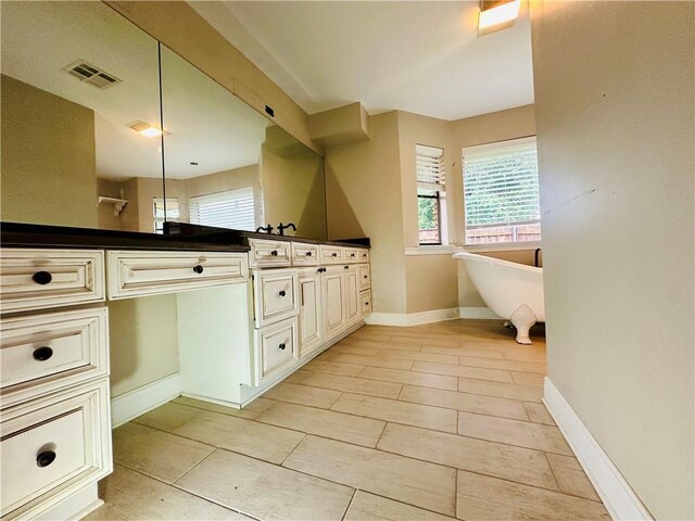 4408 Janice Ave, Metairie, LA 70003 - full bathroom with double vanity, a freestanding tub, baseboards, and tile patterned floors