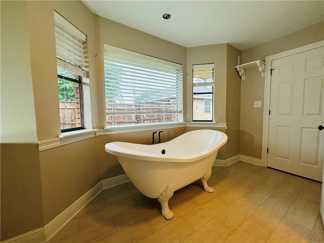 4408 Janice Ave, Metairie, LA 70003 - full bathroom featuring healthy amount of natural light, a soaking tub, wood finished floors, and baseboards