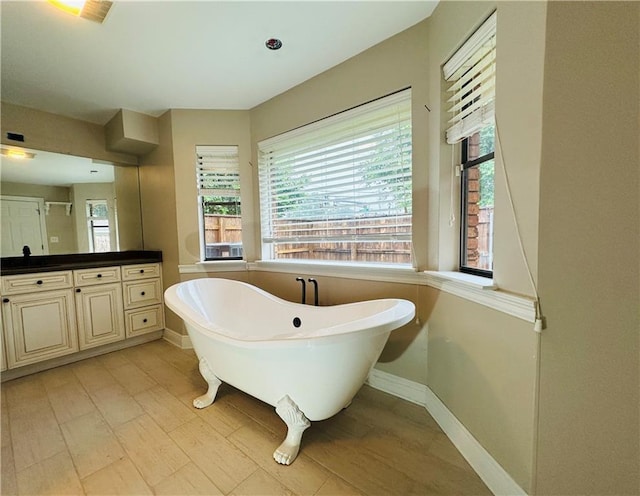 4408 Janice Ave, Metairie, LA 70003 - bathroom featuring a freestanding bath, plenty of natural light, vanity, and baseboards