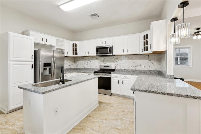838 Jefferson St, Gretna, LA 70053 - kitchen featuring appliances with stainless steel finishes, glass insert cabinets, white cabinets, and light stone counters