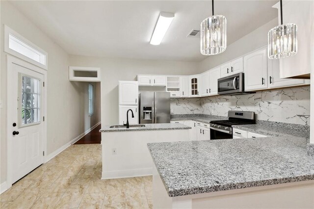 838 Jefferson St, Gretna, LA 70053 - kitchen featuring appliances with stainless steel finishes, a sink, a chandelier, and light stone counters