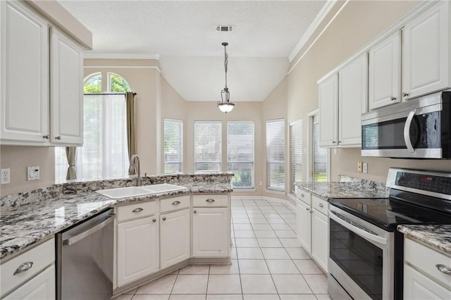 937 Crestwood Dr, Covington, LA 70433 - kitchen featuring appliances with stainless steel finishes, a sink, white cabinets, light tile patterned floors, and vaulted ceiling