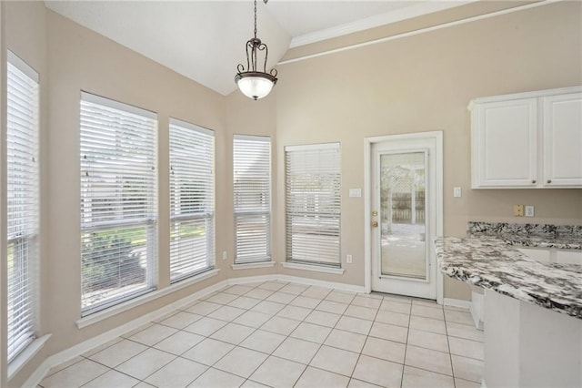 937 Crestwood Dr, Covington, LA 70433 - unfurnished dining area with baseboards, ornamental molding, light tile patterned floors, and lofted ceiling