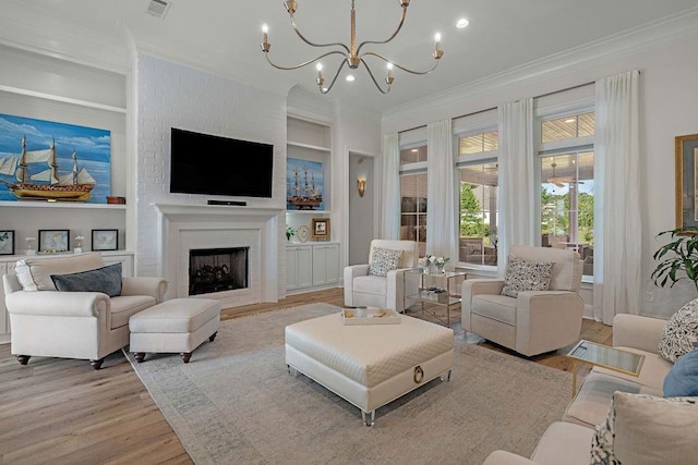 972 Camphill Dr, Abita Springs, LA 70420 - living area featuring crown molding, wood finished floors, a chandelier, built in features, and a brick fireplace