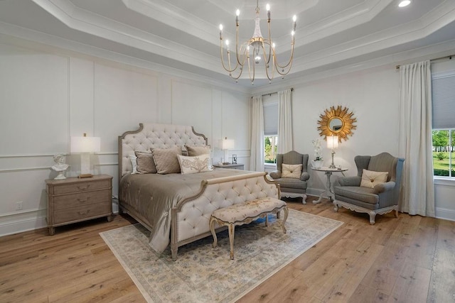 972 Camphill Dr, Abita Springs, LA 70420 - bedroom featuring a raised ceiling, crown molding, a chandelier, light wood-style flooring, and a decorative wall